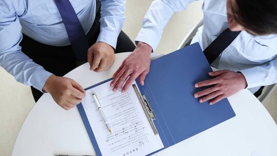 商人合作谈判并在合同上签字握手