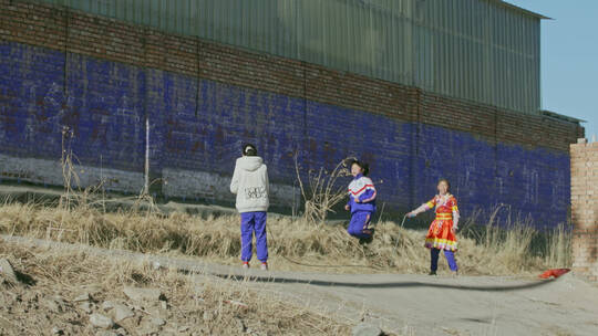 穿着藏族服饰和校服在跳绳的孩子