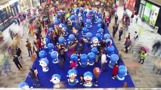 商业街人流穿梭过哆啦A梦玩偶