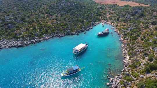 潜水旅游船停泊在土耳其的一个小海湾和游客度假者在海里游泳