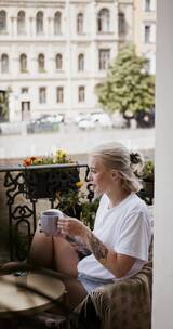 在阳台上喝咖啡的女人