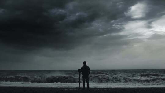 男人背影直面困难狂风乌云巨浪