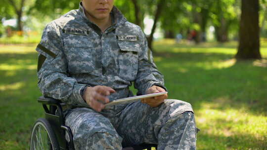 军人在轮椅上使用平板电脑视频素材模板下载