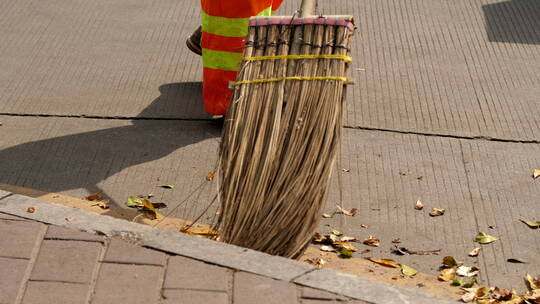 环卫工人清扫马路边的落叶