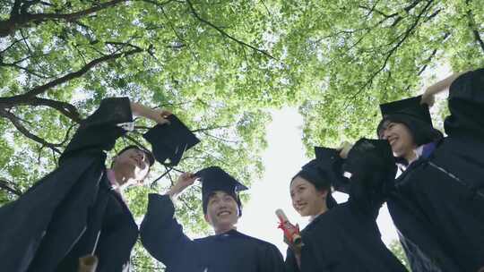 穿着学士服的大学毕业生向天上抛起学士帽