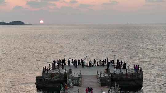 航拍威海金海湾栈桥夕阳晚霞游客海钓剪影