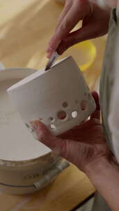 一个人拿着一个白色陶瓷锅，把它浸入白色液