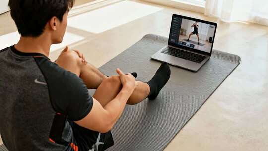 居家男性观看电脑在线健身课程运动视频