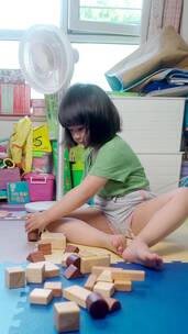 夏天坐在地上玩积木的中国女孩