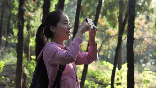 亚洲中国人女人树林旅游漫步拍照对话看风景