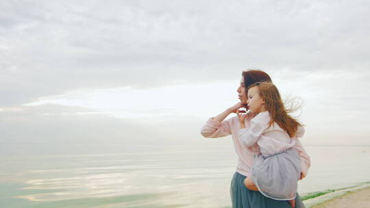 妈妈抱着女儿看海景