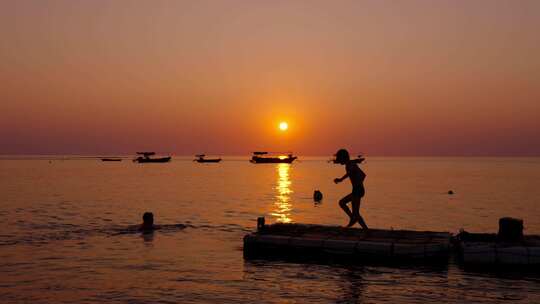 唯美海边日落夕阳下游泳玩水的小孩子