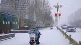 4k北方城市下大雪人行道上的外卖员高清在线视频素材下载