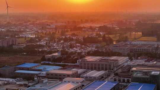 航拍平原夕阳落日房屋风力发电晚霞鸟类