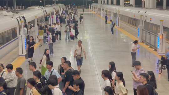 夜晚高铁站站台上下车的旅客