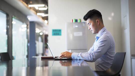 男性商务人士办公室使用笔记本电脑办公视频素材模板下载