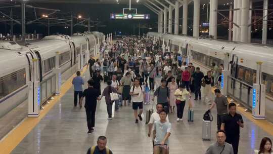 夜晚高铁站站台下车的旅客