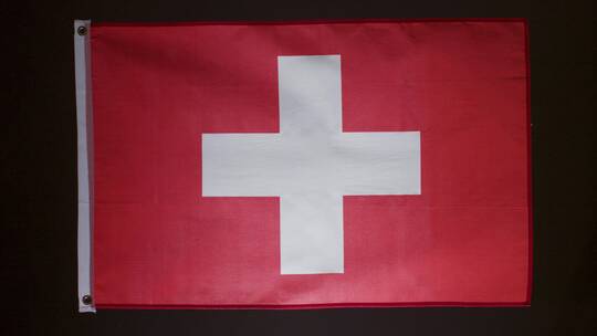 瑞士国旗在黑色背景下落下的工作室拍摄
