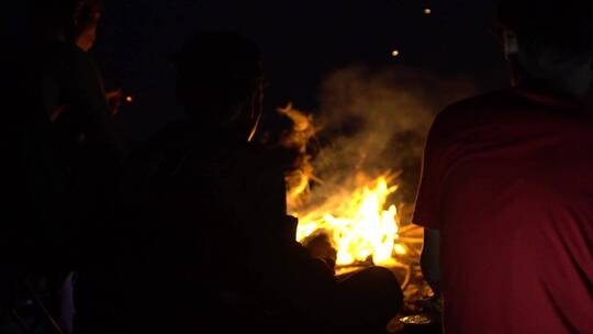 在黑暗的夜晚人们围坐在篝火旁