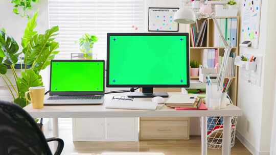 办公室桌子上的绿色屏幕笔记本台式电脑！