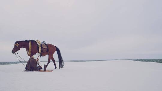 穆斯林信徒带着马在雪地里倒茶