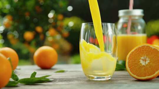 实拍美食餐饮将橙汁倒入玻璃杯的超慢速运动