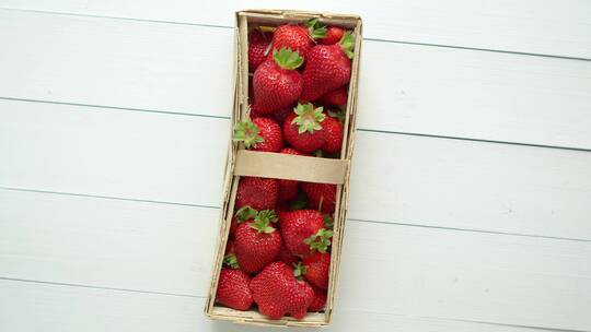 草莓放在白色背景的木箱里
