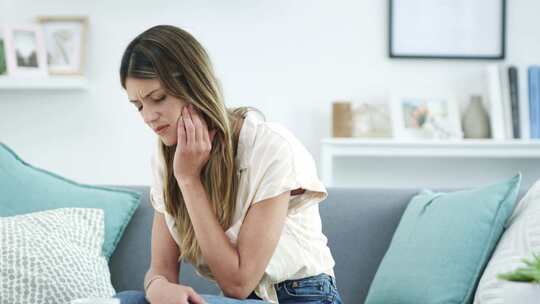 女性居家手托脸颊显不适