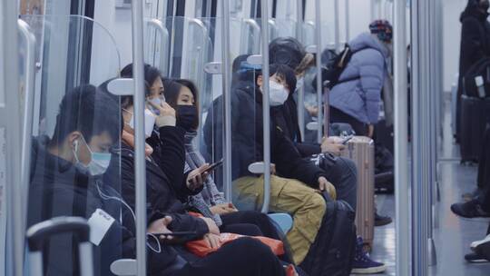 地铁上戴口罩低头族看手机