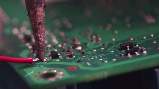 用烙铁将电子线焊接到微电路上。微电子的特写、修复
