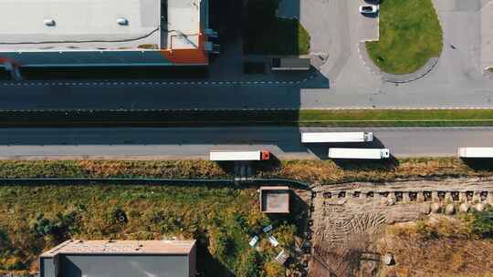 卡车沿着空荡荡的道路行驶，经过巨大的仓库