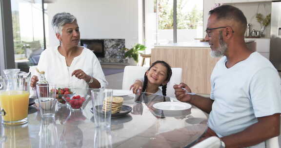 出生家庭享用早餐，孩子伸手去拿食物