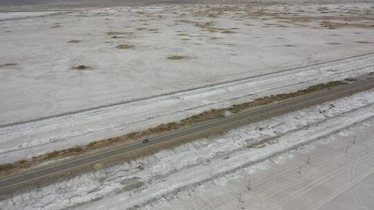 公路穿过新疆塔里木盆地荒芜的盐碱地