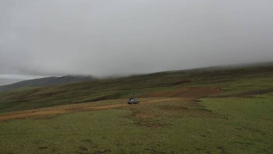 一辆汽车在西藏高原高山草甸越野行驶