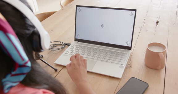 使用笔记本电脑和麦克风，亚洲女性在桌子上