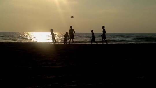 沙滩踢足球的人群剪影