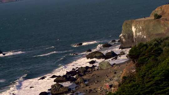 人们在岩石海岸欣赏风景