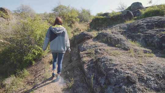 一个年轻的女旅行者在峡谷的山上散步