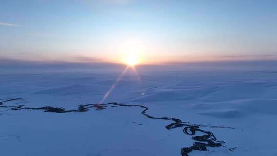 辽阔雪原蜿蜒冰封河流唯美夕阳