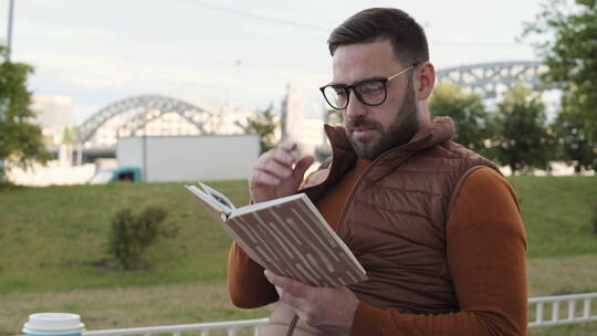 男人在户外阅读有趣的书