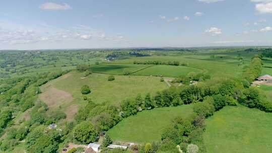 德文郡乡村山顶上一个古雅的英国村庄上空的空中跟踪