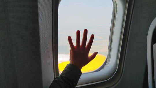 小男孩把手放在窗户上