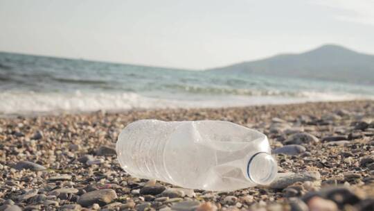 丢弃在沙滩上的废弃塑料瓶的特写视频素材模板下载