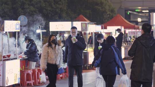 都市夜晚市民逛夜市小吃摊散步休闲生活