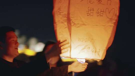 夜晚年轻人放孔明灯