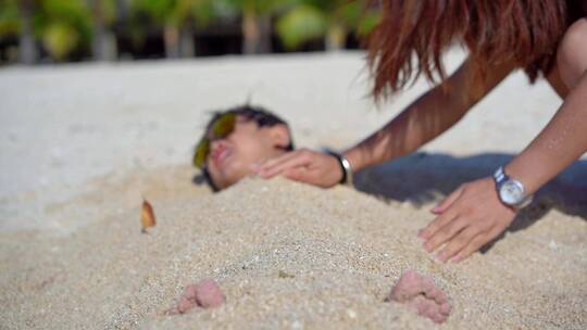 小男孩沙滩开心玩沙子埋掉自己