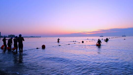辽宁葫芦岛兴城滨海沙滩清晨下海游泳的人群