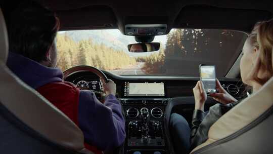 司机驾驶汽车，乘客拍摄道路。