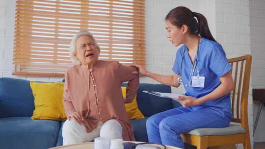 亚洲护理护士检查背痛的高级女性患者。视频素材模板下载