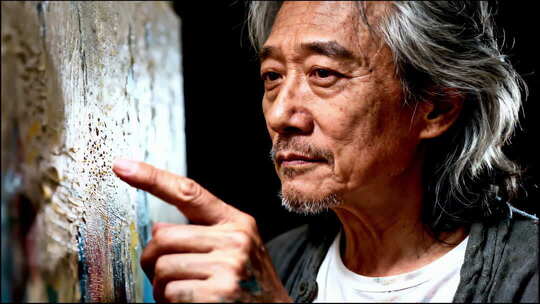 老年艺术家指点画作